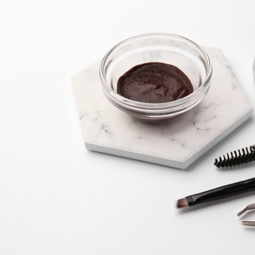 Eyebrow henna and professional tools on white background, space for text